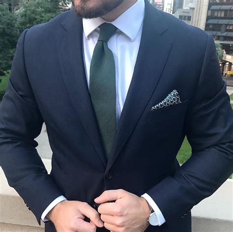 navy blue suit with green tie